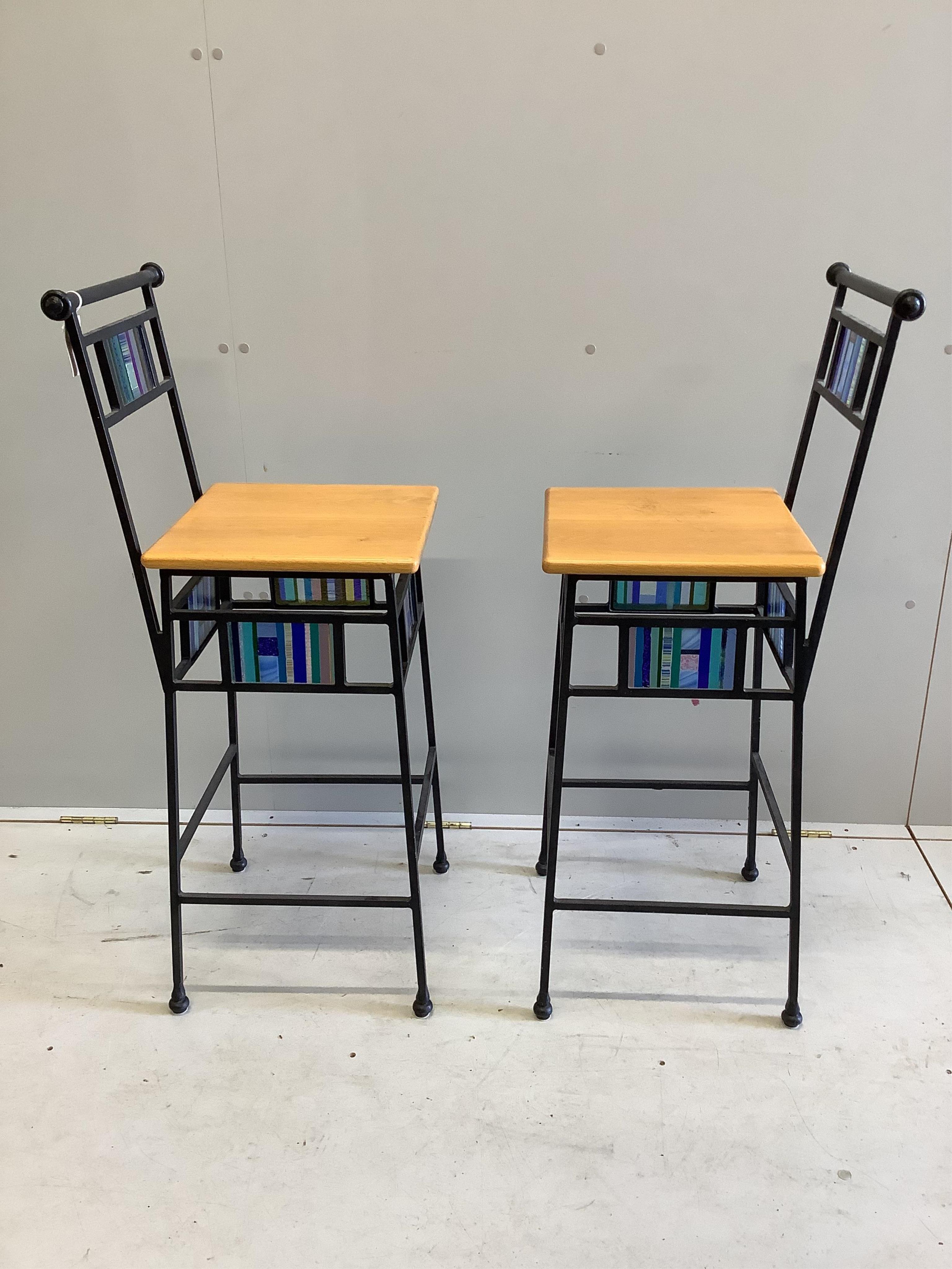 A pair of wrought iron and gold oak bar stools with coloured glass panelling, width 37cm, height 104cm. Condition - fair